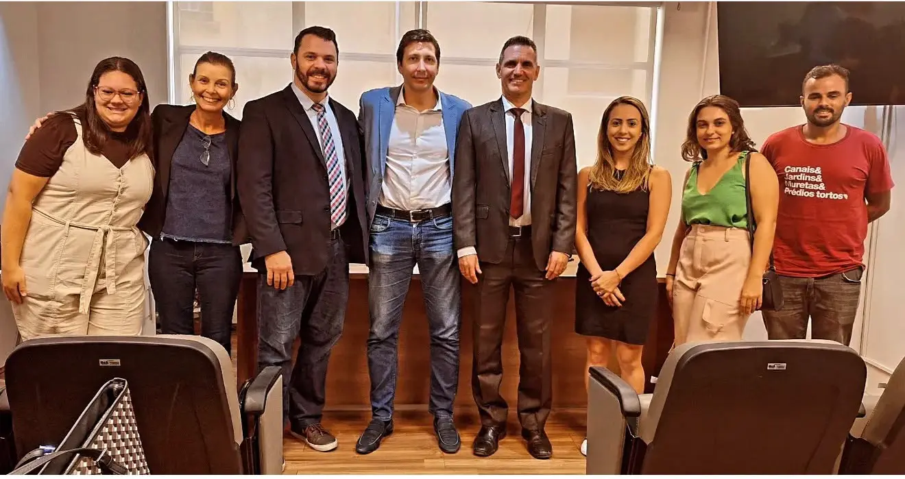 Edson Rodrigues Eduardo com um grupo de profissionais em uma sala de reunião