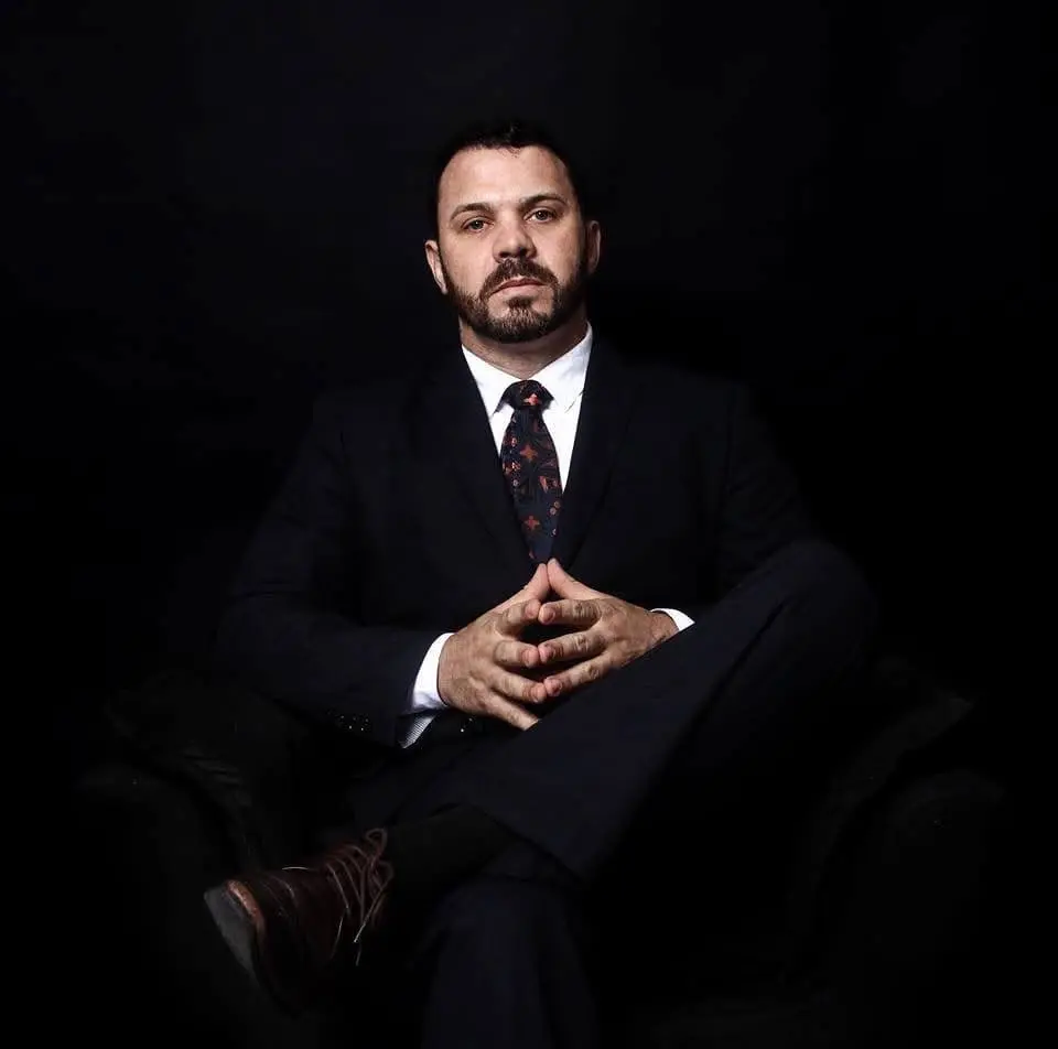 Retrato de Edson Rodrigues Eduardo sentado, usando terno escuro